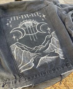 a denim jacket with an image of the moon and stars on it