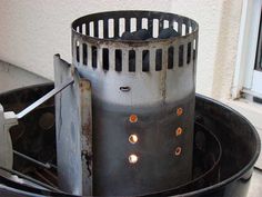 an old metal fire pit sitting on top of a black table next to a window