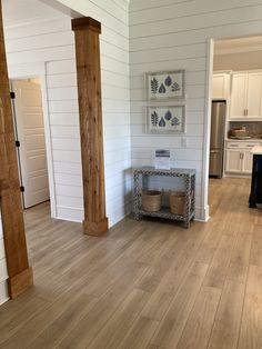 an open floor plan with white walls and wood floors