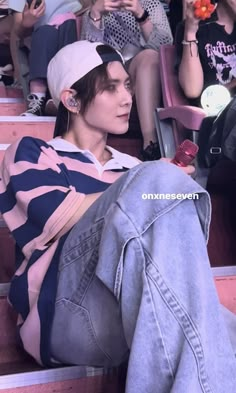 a woman sitting on the bleachers with her leg up in front of her