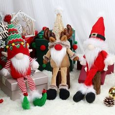 three christmas gnomes are standing next to each other in front of presents and decorations