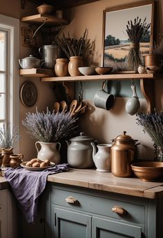 pots and pans are on the shelf above the kitchen counter, with lavender in vases