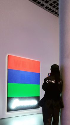 a person standing in front of a colorful painting