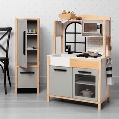 a small kitchen with an oven, sink and cupboards in the corner next to a dining room table