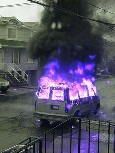 a van is on fire with purple flames coming out of it's back windows