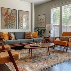 a living room with couches, chairs and rugs on the floor in front of windows