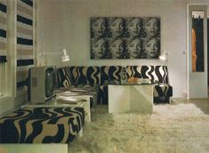 a living room with zebra print furniture and pictures on the wall