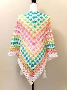 a multicolored crocheted shawl on a mannequin