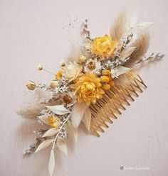 a hair comb with flowers and feathers on it's side, against a white background