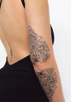 the back of a woman's body with tattoos on her left arm and shoulder