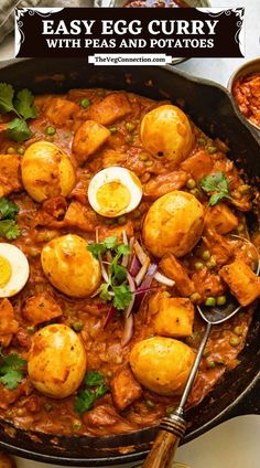 an easy egg curry with peas and potatoes in a skillet on a white table