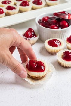 someone is picking up some small desserts from the table