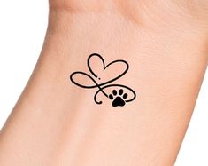 a dog paw with a heart tattoo on it's left wrist and the word love is written in black ink