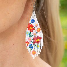 Introducing the Carmen de Viboral Earrings, a stunning homage to the artistry of a charming Colombian town renowned for its exquisite hand-painted china adorned with floral designs. These beautiful earrings feature pristine white beads embellished with vibrant, colorful flower details, all meticulously handwoven with the finest Czech beads. Perfectly capturing the essence of summer, the Carmen de Viboral Earrings add a touch of elegance and warmth to any outfit. Let these exquisite earrings brin Spring White Jewelry With Matching Earrings, White Jewelry With Matching Earrings For Spring, White Bohemian Beaded Dangle Earrings, White Flower Earrings With Flower Decoration For Summer, White Flower Earrings With Summer Decoration, White Summer Flower Earrings, White Bohemian Beaded Earrings With Dangling Beads, White Bohemian Jewelry With Dangling Beads, White Bohemian Beaded Dangling Earrings