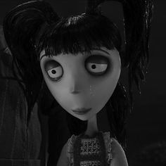 a creepy doll with big eyes and black hair standing next to a man in a dark room