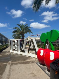 people are standing in front of the entrance to a building with large letters and fruit decorations