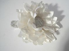 a white flower brooch sitting on top of a table