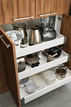 an open cabinet with pots and pans on it