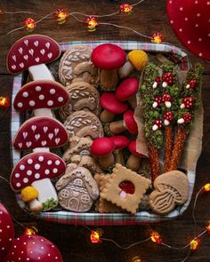 an assortment of decorated cookies in a basket on a table with red balloons and string lights