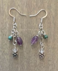 This pair of earrings are made with a silver plated hook and chain; flower pendant, hanging approximately 1.5" from the base of the earring hook.   Earrings are mounted with stoppers on a Flower Series card.   Stones: Amethyst Quartz Magnesite dyed No two stones are the same.   There may be a slight variation in color, size, shape, internal lines and approximate length from one stone to the next.   There may be a slight variation from the computer sample to the purchased pair of earrings. Clean with a soft jewelry polishing cloth.  Do not submerge gemstones in a silver polishing solution. Thank you for your purchase! Soft Jewelry, Amethyst Flower, Flower Cluster, Earring Hook, Amethyst Quartz, Flower Pendant, Hook Earrings, Leeds, A Flower