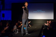 a man standing on top of a runway in front of a crowd