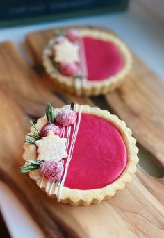 two small tarts sitting on top of a wooden cutting board