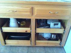 an open cabinet with dishes and cups in it