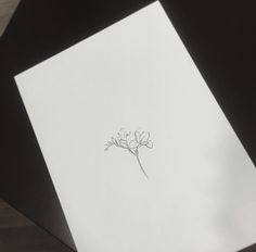 a piece of paper with a drawing of a flower on it sitting on top of a table