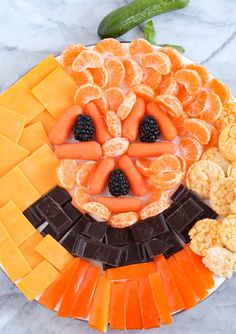 a plate topped with fruit and crackers on top of a marble countertop next to a plant