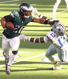 a football player running with the ball in his hand and another person behind him holding it