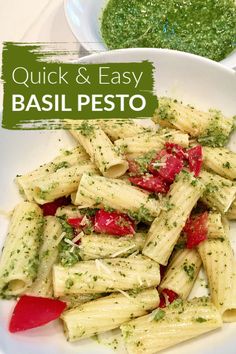 pasta with pesto and tomatoes on a white plate next to a bowl of pesto