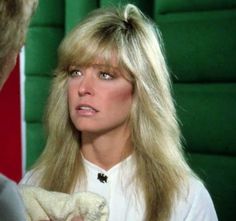 a woman with long blonde hair holding a towel