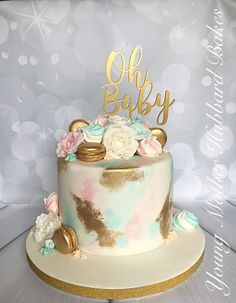 there is a cake that has been decorated with flowers and gold lettering on it,