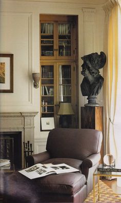 a living room filled with furniture and a fire place in front of a book shelf