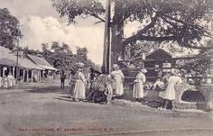 an old black and white photo of people standing in front of a building with trees