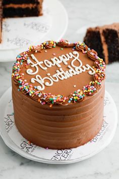 there is a chocolate cake with sprinkles on it and the words happy birthday written in frosting