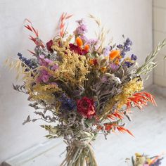 a vase filled with lots of different colored flowers