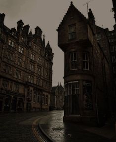 an empty street with old buildings on both sides and dark clouds in the sky above