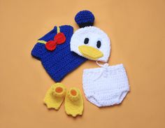 a crocheted hat, diaper cover and booties are laid out on a table