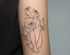 a woman's arm with flowers and a cat tattoo on the left inner arm