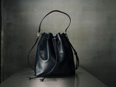 "I create my bags with high attention for details and I always respect high standards of quality. For this bag I used a soft Italian leather that gives a pleasant feeling at touch and I added all the features you would like to have on a bucket bag. The inside is fully lined and it has 3 pockets, one of them closed with a zipper for quick-access items, where you can keep your keys, your phone and other small thing that we normally lose in the abyss of our bags. To have a more secured bag, it clos Luxury Blue Rectangular Bucket Bag, Everyday Pouch Bags With Leather Handles, Everyday Leather Bucket Pouch, Navy Blue Bag, Work Chic, The Abyss, Leather Bucket Bag, Leather Gifts, Leather Bucket