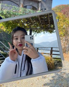 a woman taking a selfie in front of a mirror with the reflection of her