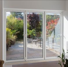 a living room with sliding glass doors leading to a patio area and outdoor dining table