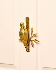 a decorative gold bird on a white door