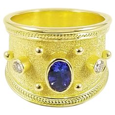 This S.Georgios designer 18 Karat solid Yellow Gold Band Ring is all handmade and has microscopic Byzantine granulation workmanship and a unique velvet background. The gorgeous ring features a center Oval cut Tanzanite total weight of 0,90 Carats and 2 Brilliant cut White Diamonds total weight of 0,18 Carats. This band snugs and is very comfortable to wear every day and we make this gorgeous piece also in all White, or Rose Gold, please contact us. This ring-like all the Georgios Collections pie Wide Diamond Bands, Velvet Background, Kunzite Ring, Wide Band Ring, Tanzanite Diamond, Gold Band Ring, Wide Band Rings, Diamond Rings Bands, Sapphire Jewelry