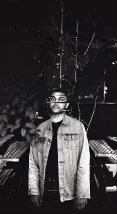 a black and white photo of a man standing in front of a table with food on it