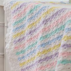 a crocheted baby blanket with multicolored stripes