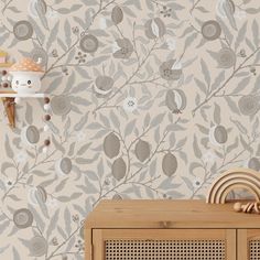 a wooden cabinet sitting in front of a wall with a flower pattern on it's side