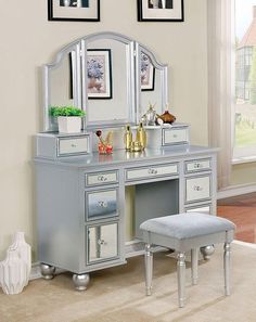 a vanity with mirror, stool and pictures on the wall