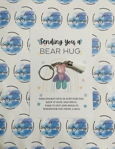 a keychain with a teddy bear on it sitting in front of a blue and white background